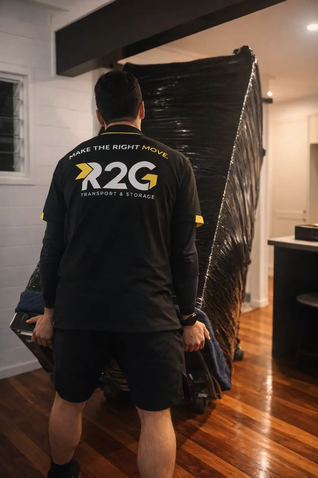 R2G crew moving a wrapped household item R2G crew member moving a wrapped household item inside a home